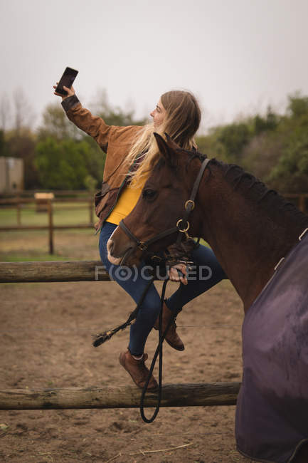 Девочка-подросток делает селфи с лошадью на ранчо — стоковое фото