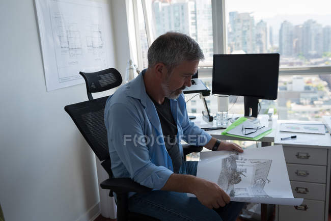 Reifer Mann schaut auf Architekturkarte — Stockfoto