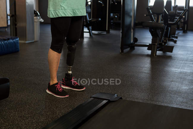 Disabled woman in prosthetic leg at gym — Stock Photo