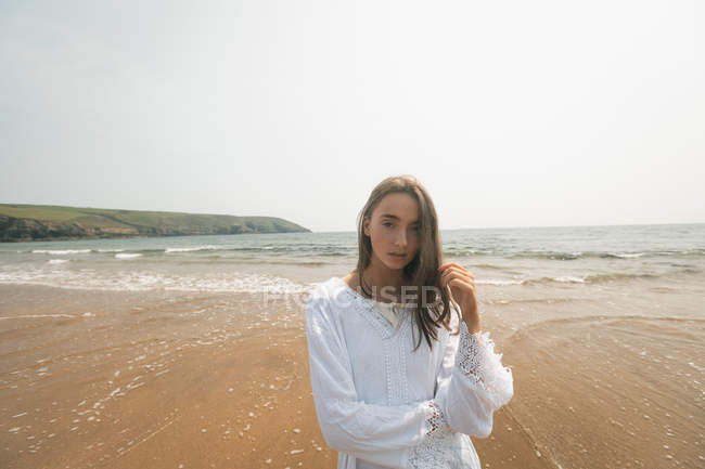 Schöne Frau am Strand an einem sonnigen Tag — Stockfoto