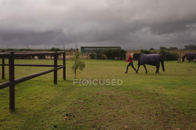Ragazza adolescente che cammina con il cavallo nel ranch — Foto stock