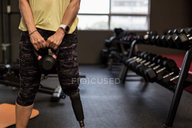 Mittelteil einer behinderten Frau, die im Fitnessstudio an einem Gerät trainiert — Stockfoto