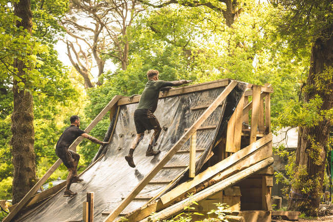 Вмістити чоловіків тренуватися над перешкодами в таборі для завантаження — стокове фото