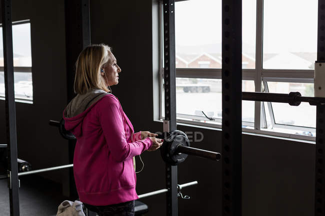 Femme mature handicapée utilisant un téléphone portable dans la salle de gym — Photo de stock
