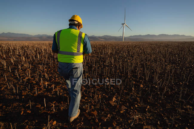 Вид спереду інженера, що ходить на вітроелектростанції — стокове фото