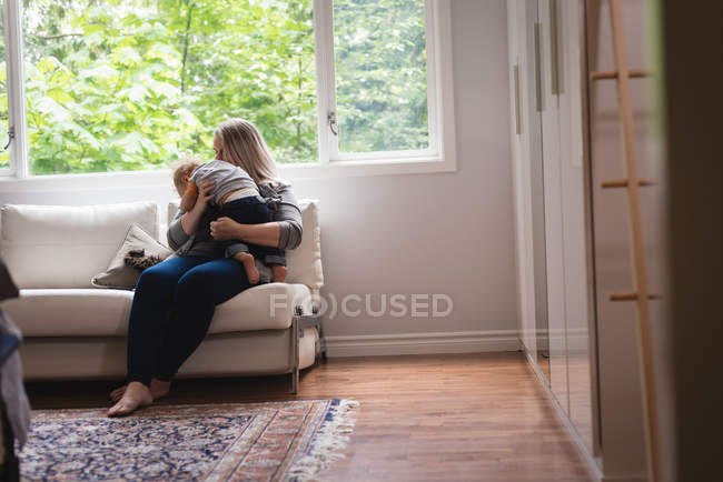 Мати грає з дитиною на дивані вдома — стокове фото