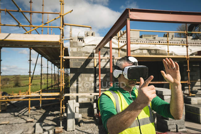 Інженер відчуває гарнітуру VR на будівельному майданчику в сонячний день — стокове фото