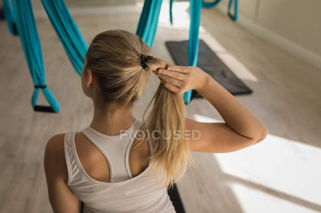 Visão traseira da mulher com as mãos no cabelo no estúdio de fitness — Fotografia de Stock