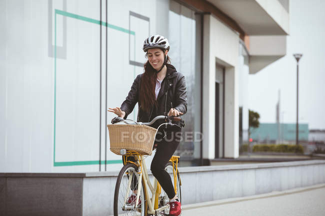 Beautiful woman in helmet riding bicycle — Stock Photo