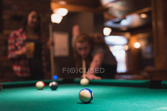 Couple playing snookers in night club — Stock Photo