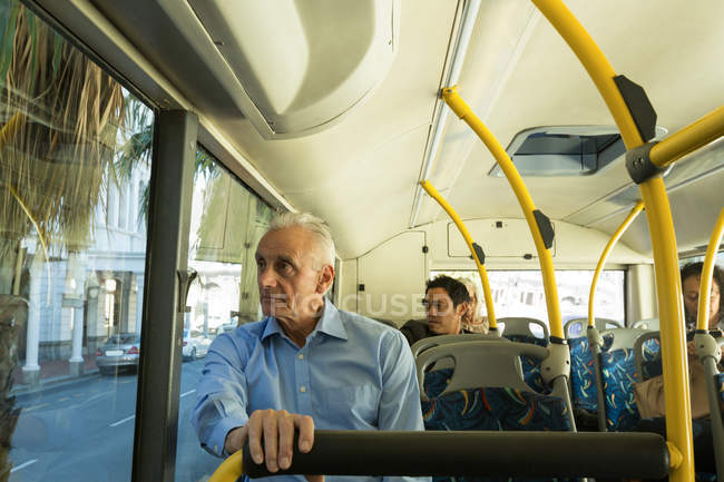 Uomo anziano che guarda attraverso la finestra mentre viaggia in autobus — Foto stock
