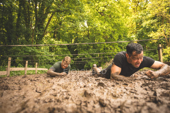 Fit men training under obstacle course at boot camp — Stock Photo