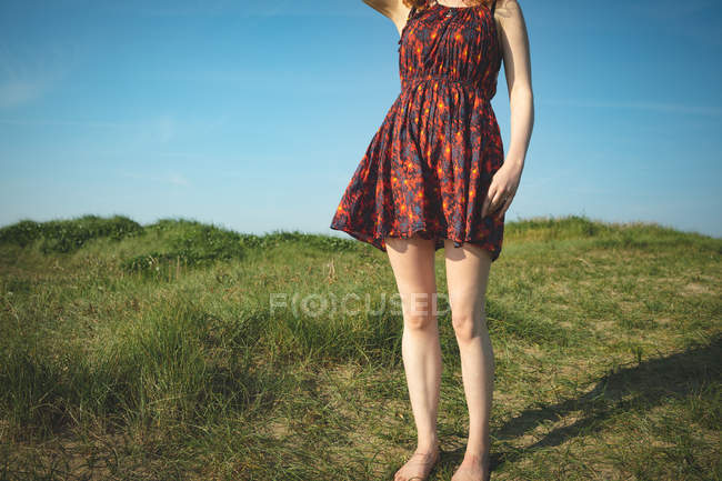 Низька частина жінки, що стоїть на пагорбі біля узбережжя моря — стокове фото