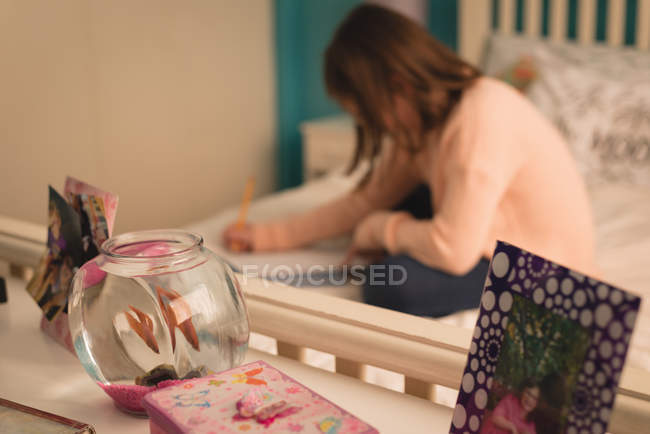 Девочка учится дома в спальне — стоковое фото