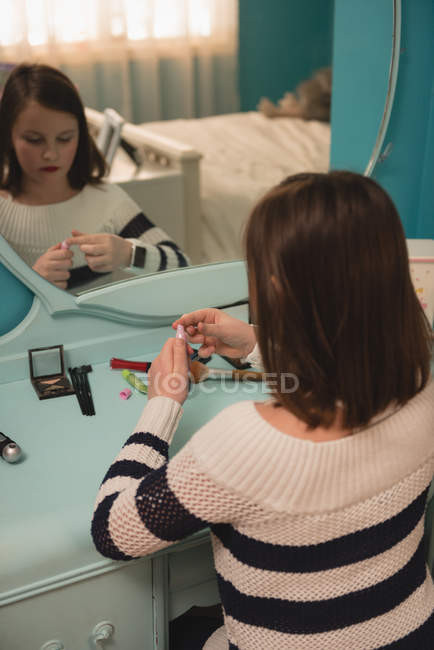 Menina aplicando batom no quarto em casa — Fotografia de Stock