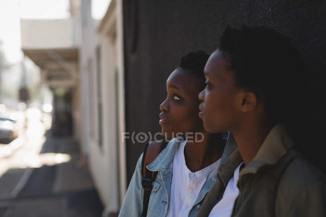 Thoughtful twins siblings standing together in city street — Stock Photo