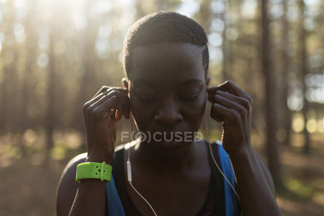 Close-up de atleta feminina ouvindo música em fones de ouvido — Fotografia de Stock