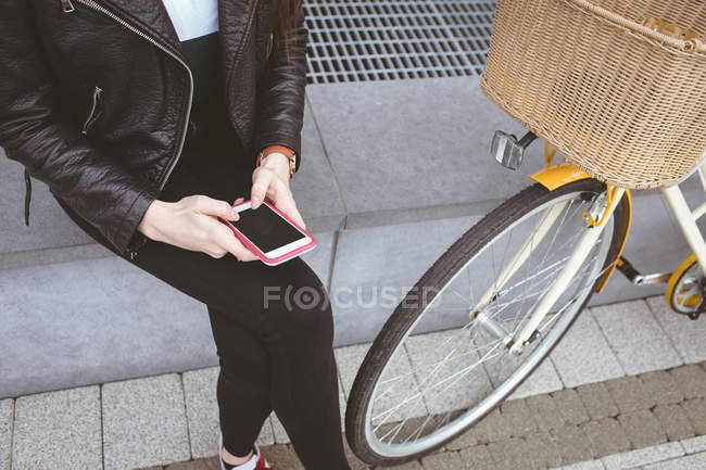Sezione bassa di donna che utilizza il telefono cellulare sul marciapiede — Foto stock