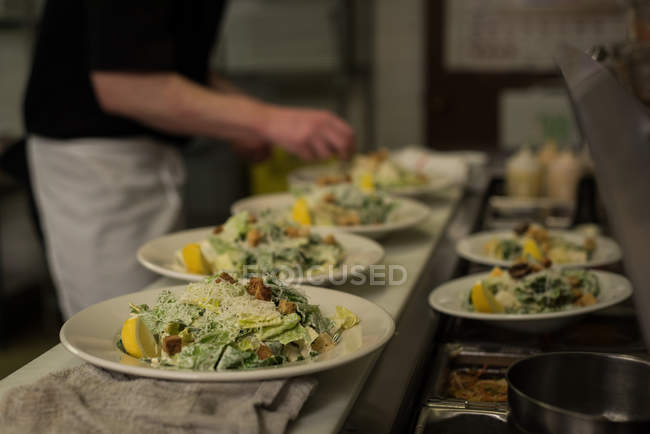 Männlicher Koch serviert Essen in der Küche im Restaurant — Stockfoto