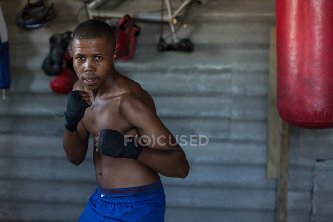Portrait of male boxer practicing boxing in fitness studio — Stock Photo