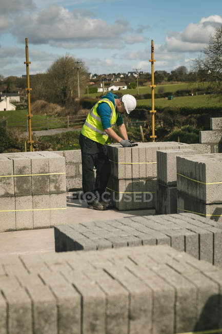 Concentrated engineer standing between the concrete slabs using tablet — Stock Photo