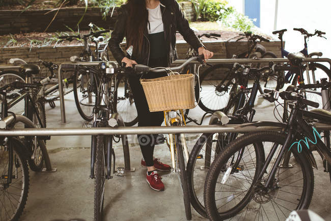 Donna che parcheggia la sua bicicletta al cavalletto — Foto stock