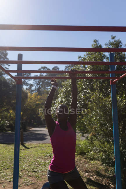 Atleta feminina determinada se exercitando em barras de macaco — Fotografia de Stock
