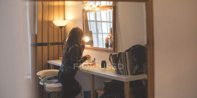 Modelo aplicando batom no vestiário no estúdio de fotografia — Fotografia de Stock