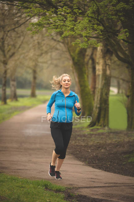 Schöne schwangere Frau beim Joggen im Park — Stockfoto