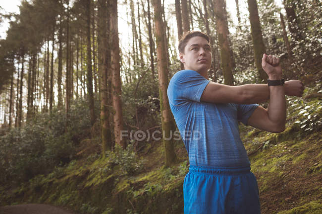 Junger Mann streckt sich im Wald — Stockfoto