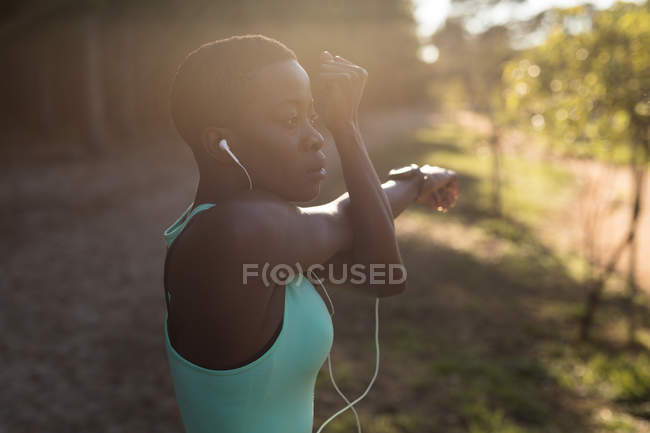 Deportista femenina decidida a escuchar música mientras hace ejercicio matutino - foto de stock