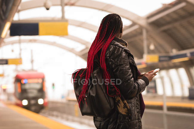 Mulher elegante usando telefone celular na plataforma ferroviária — Fotografia de Stock