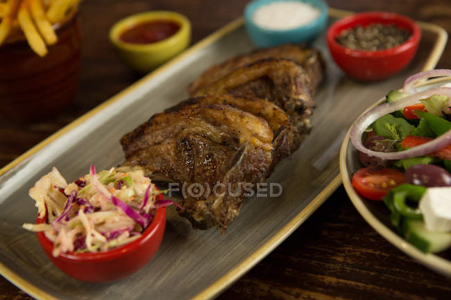 Крупный план жареного мяса с салатом в лотке — стоковое фото