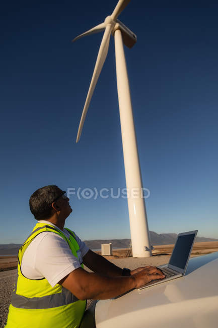 Інженер використовує ноутбук на вітроелектростанції — стокове фото