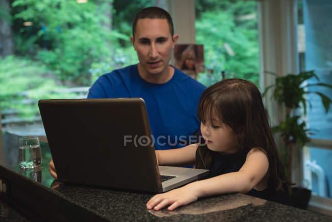 Батько і дочка використовують ноутбук разом вдома — стокове фото