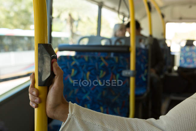 Pessoa mão pressionando botão no pólo enquanto viaja no ônibus — Fotografia de Stock
