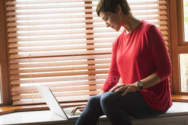Крупним планом жінка використовує ноутбук у вітальні вдома — стокове фото