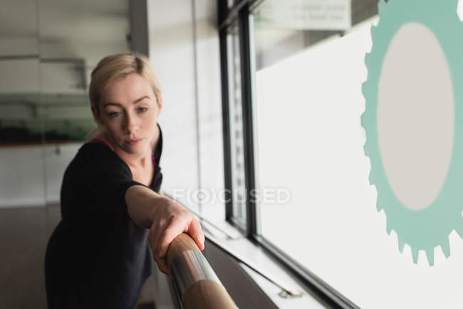 Молодая женщина растягивается на барре в тренажерном зале — стоковое фото