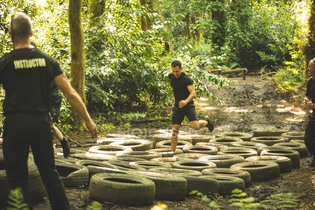 Adatta agli uomini allenamento su pneumatici percorso ad ostacoli al campo di addestramento — Foto stock