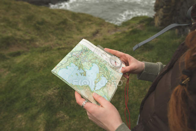 Close-up of female hiker reading a map at the sea coast — Stock Photo