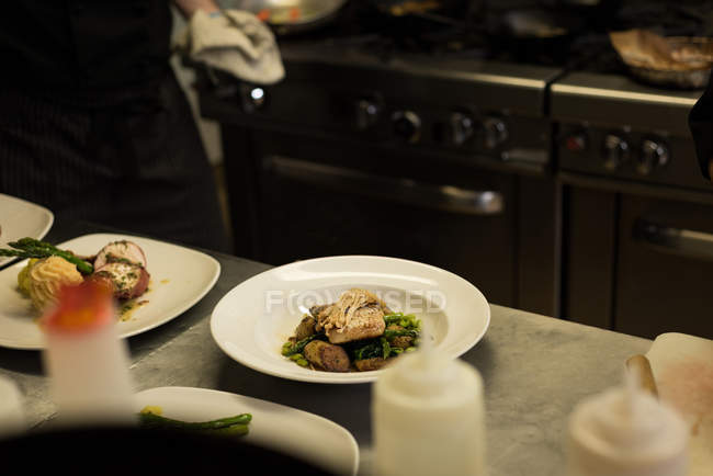 Еда подается в тарелке на кухне — стоковое фото