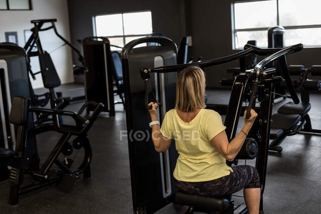 Femme handicapée faisant de l'exercice sur machine dans la salle de gym — Photo de stock