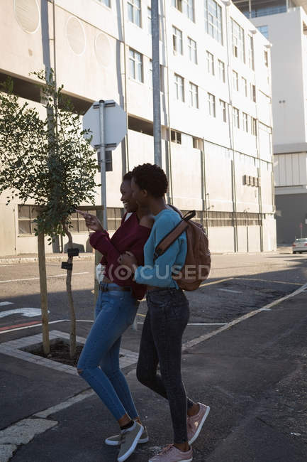 Близнецы веселятся на городской улице в солнечный день — стоковое фото