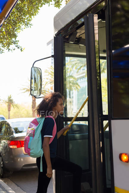 Подростковая девочка садится в автобус на улице — стоковое фото