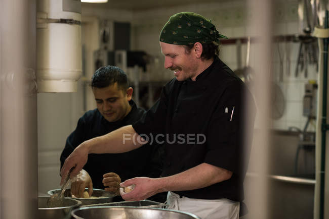 Chefs masculinos preparando comida na cozinha no restaurante — Fotografia de Stock