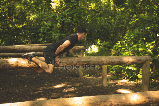 Вмістити чоловіка тренуватися на фітнес-трейл в таборі для завантаження — стокове фото