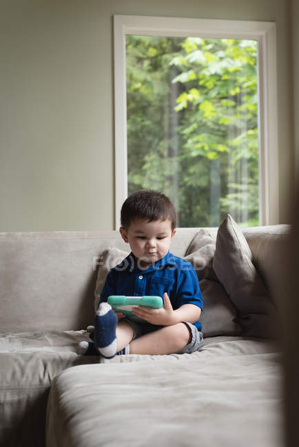 Niño usando tableta digital en la sala de estar en casa - foto de stock