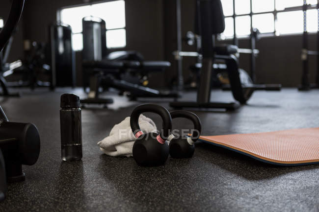 Kettlebells with water bottle and towel in the gym — Stock Photo
