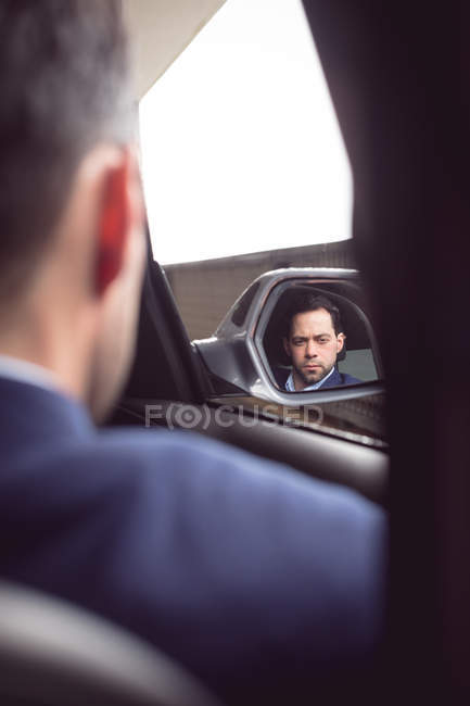 Vue arrière d'un homme d'affaires conduisant une voiture — Photo de stock