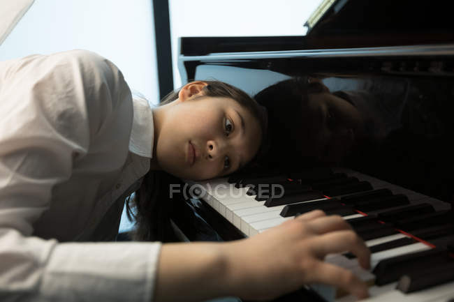 Adorable schoolgirl playing piano in music school — Stock Photo
